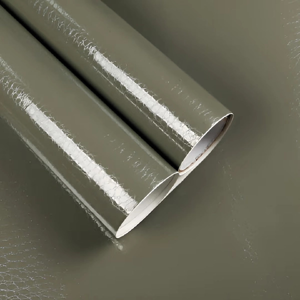 A roll of glossy solid color vinyl wrap in a dark green or olive hue.
