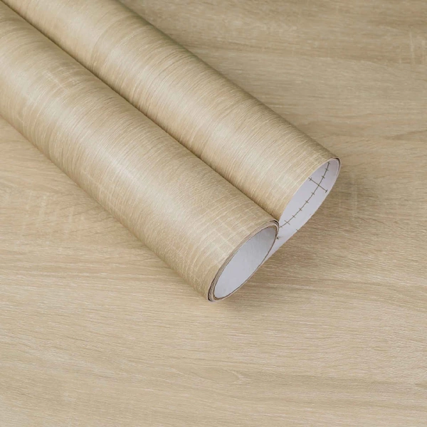 A roll of light-colored wood grain patterned vinyl wrap.