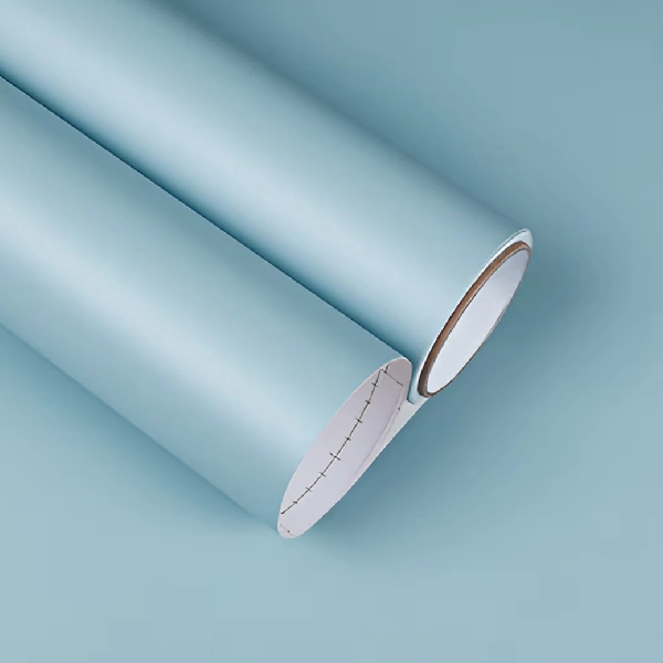A roll of matte solid color vinyl wrap in a light blue or powder blue hue.