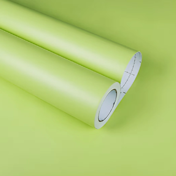 A roll of matte solid color vinyl wrap in a light green or chartreuse hue.