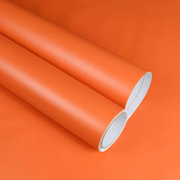 A roll of matte solid color vinyl wrap in a vibrant orange hue.