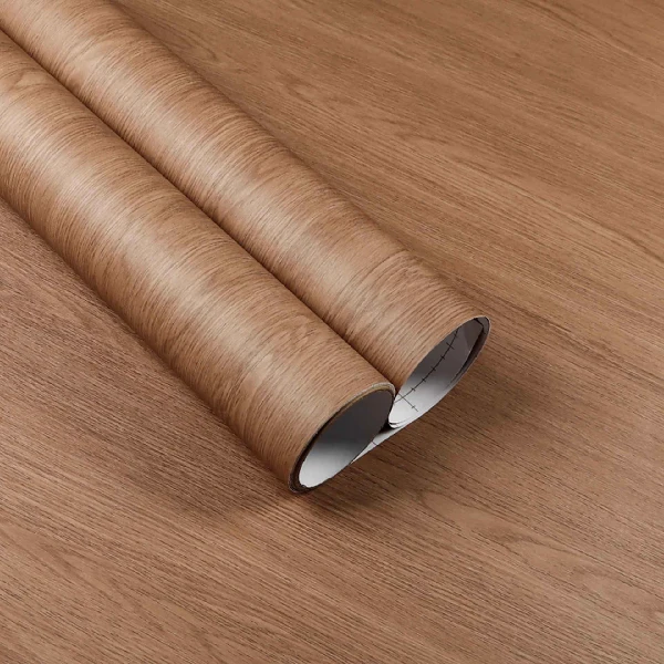 A roll of reddish-brown wood grain patterned vinyl wrap.