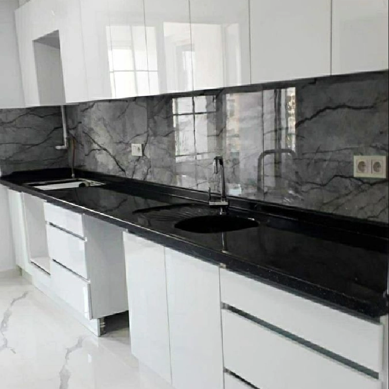 Black marble-patterned vinyl wrap with white veins on a glossy kitchen backsplash.