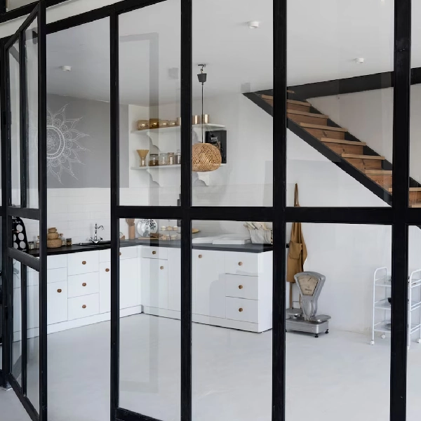 Black window frame vinyl wrap with clear glass separating a kitchen and dining