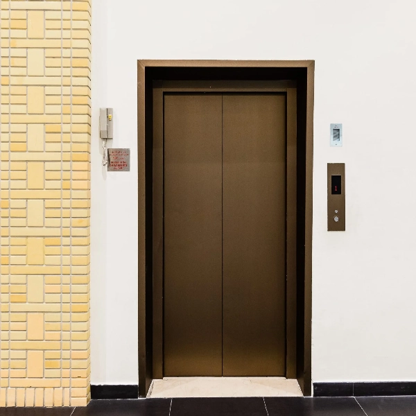 Brown-metallic vinyl wrapped elevator doors in a white hallway.