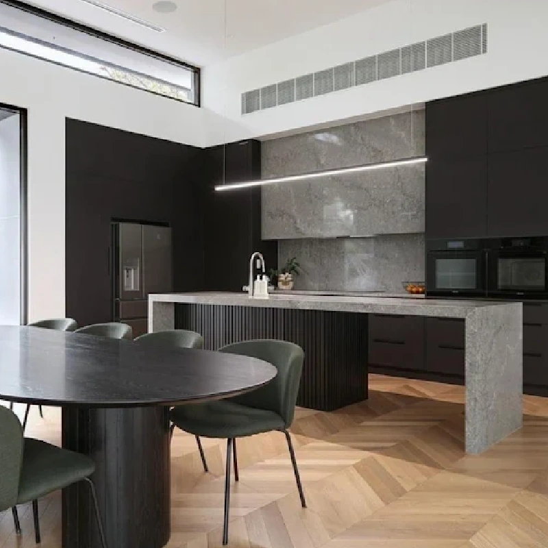Dark modern kitchen with gray vinyl wrap backsplash and countertop.