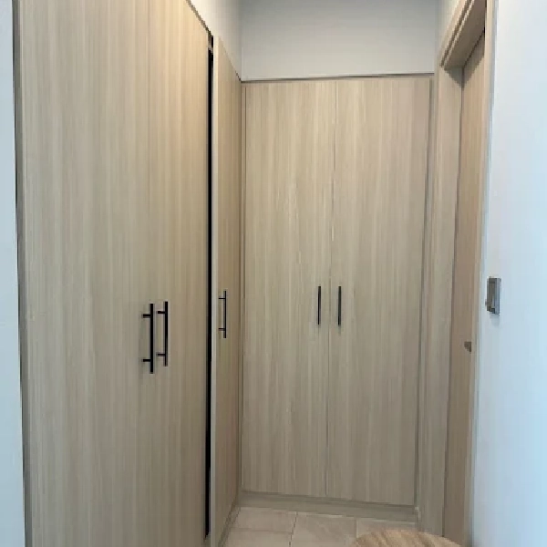 Floor-to-ceiling wooden wardrobe with dark handles.