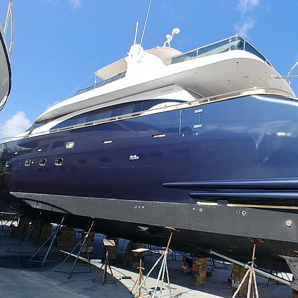 Large dark blue yacht in dry dock.