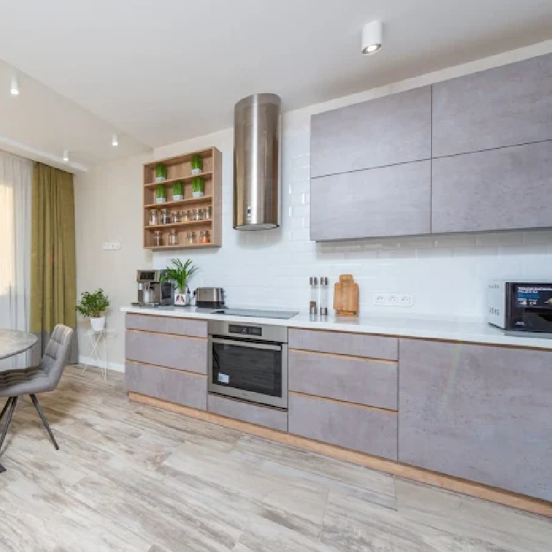 Light gray kitchen cabinets with a vinyl wrap finish and wood trim.