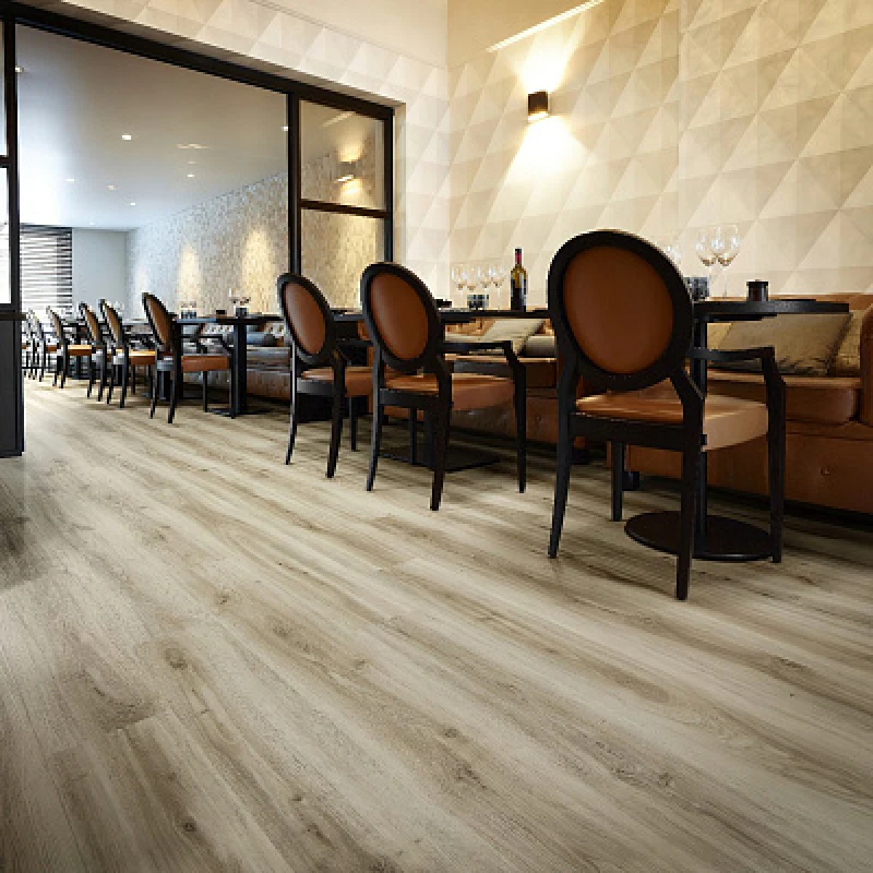 Light gray wood grain vinyl wrap on a restaurant floor with tables and chairs.