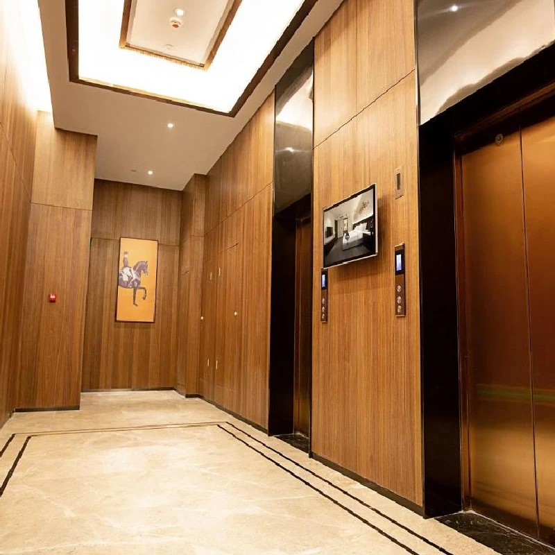 Lobby with woodgrain vinyl wrap on the walls and elevator.