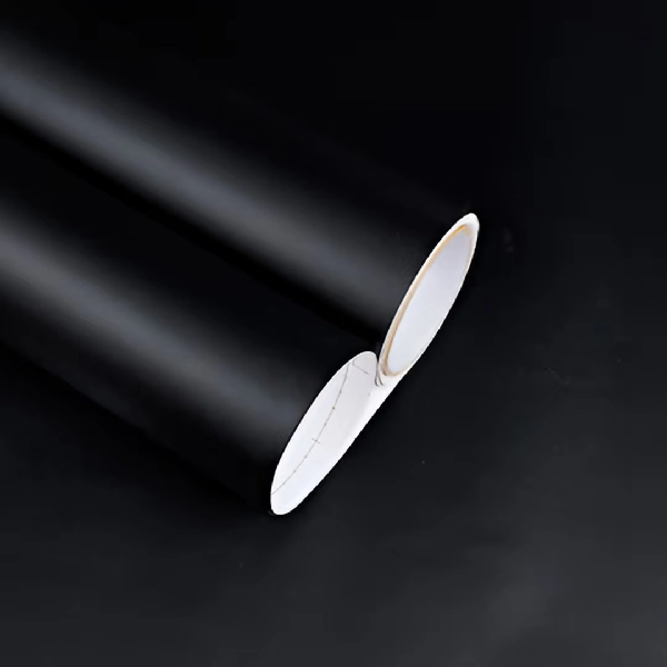 Rolls of matte black solid vinyl wrap.