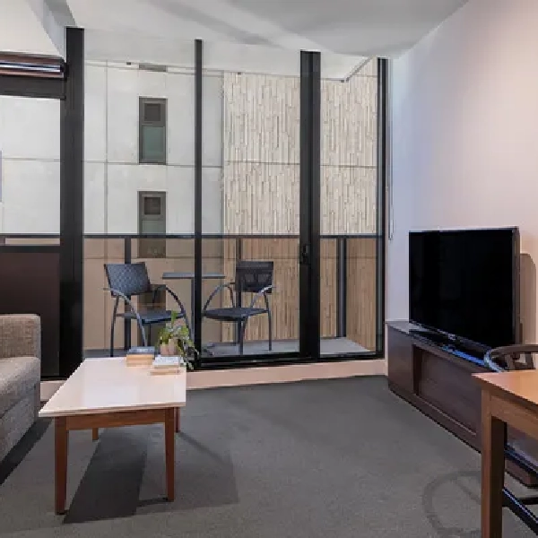 Room with a balcony, television, and small table.