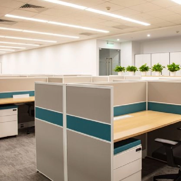 Rows of office cubicles with teal and beige dividers.