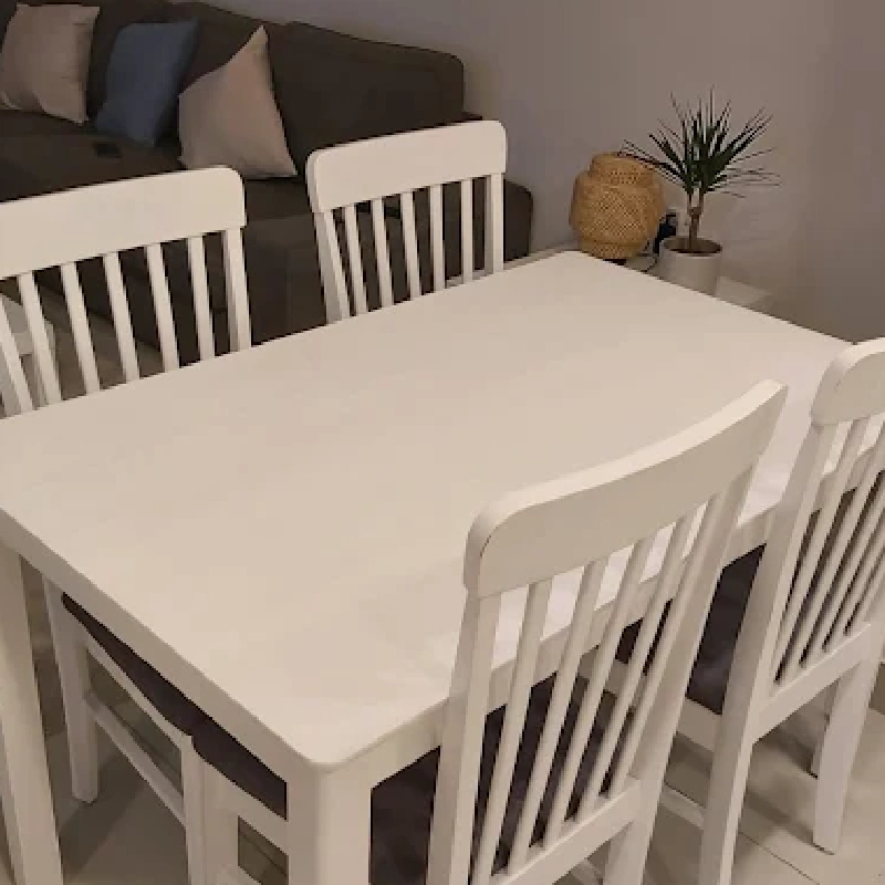 White furniture set, including a rectangular table and chairs, covered in vinyl wrap.
