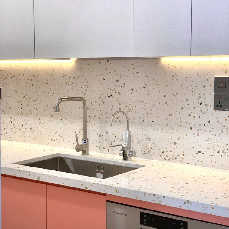 White terrazzo-patterned vinyl wrap on a kitchen backsplash.