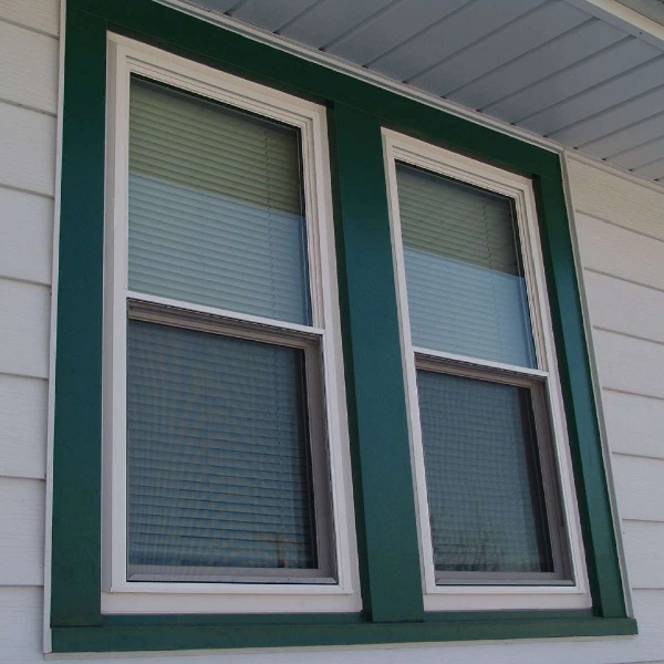 White window frames with a dark green vinyl wrap trim.