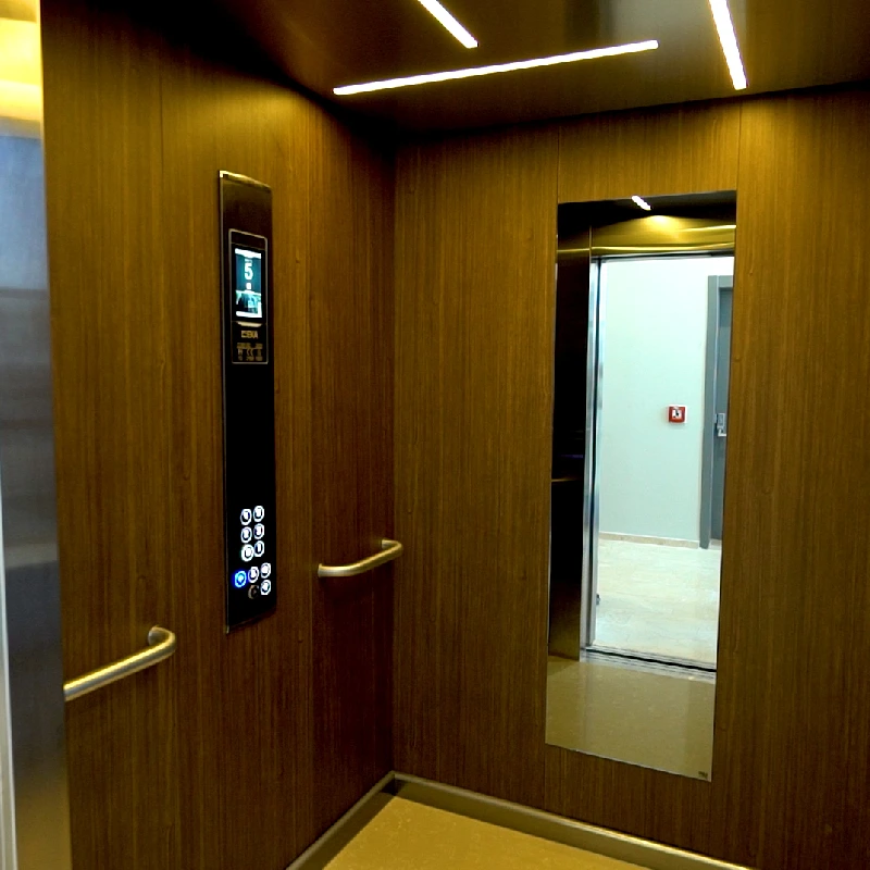 elevator with woodgrain vinyl wrapped walls and a black touch screen control panel.