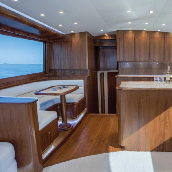 interior of a yacht's cabin, featuring dark wood vinyl wrap on the walls and flooring