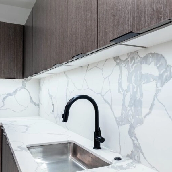 kitchen cabinets with a white marbled backsplash and counter.