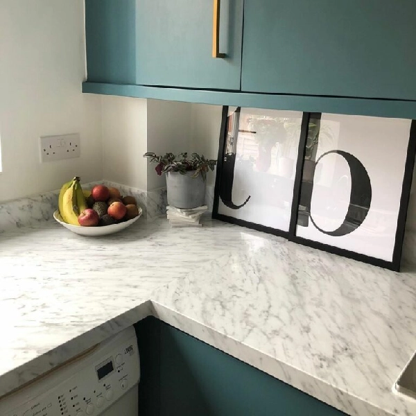kitchen cabinets with a white marbled vinyl wrap countertop.