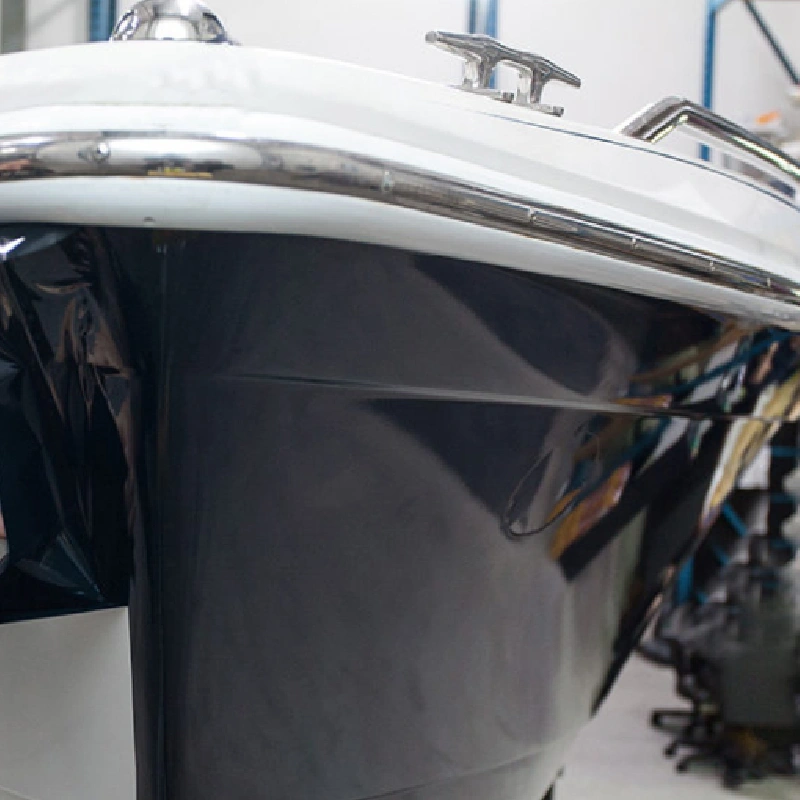 large, sleek black yacht with a vinyl wrap cruises through the water