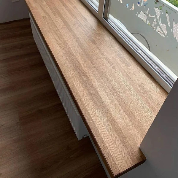 window frame and radiator with a wooden vinyl wrap windowsill