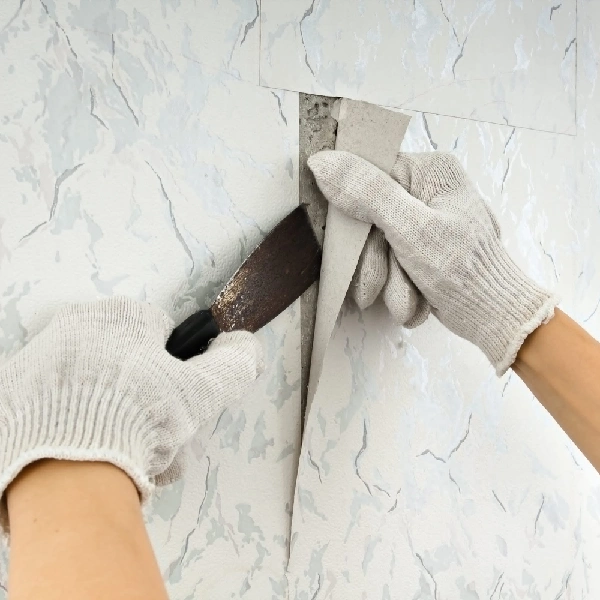 tool to work on a seam or peel a section of marble-patterned wallpaper